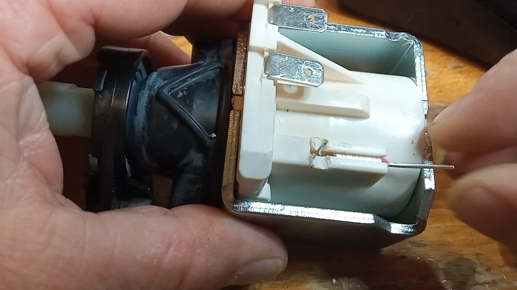 El fusible térmico está alojado en el cuerpo de plástico situado junto a la bobina de la bomba.